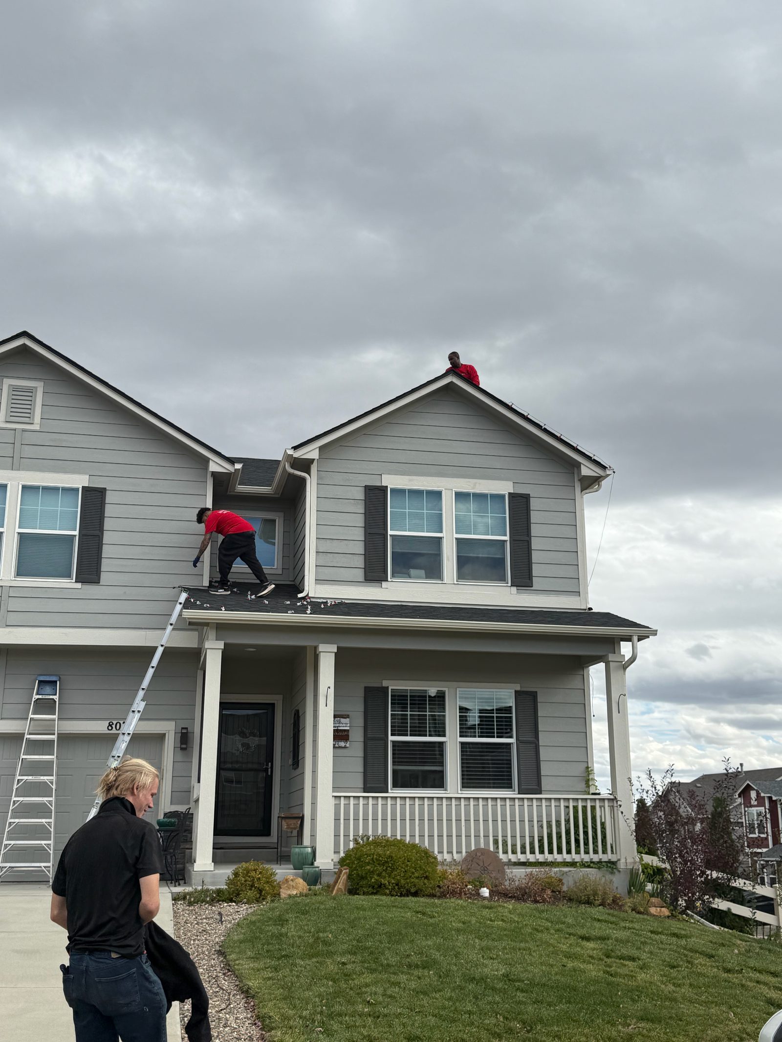 Christmas Lights Colorado Springs crew installing warm white C9 Christmas lights on a two-story home roofline