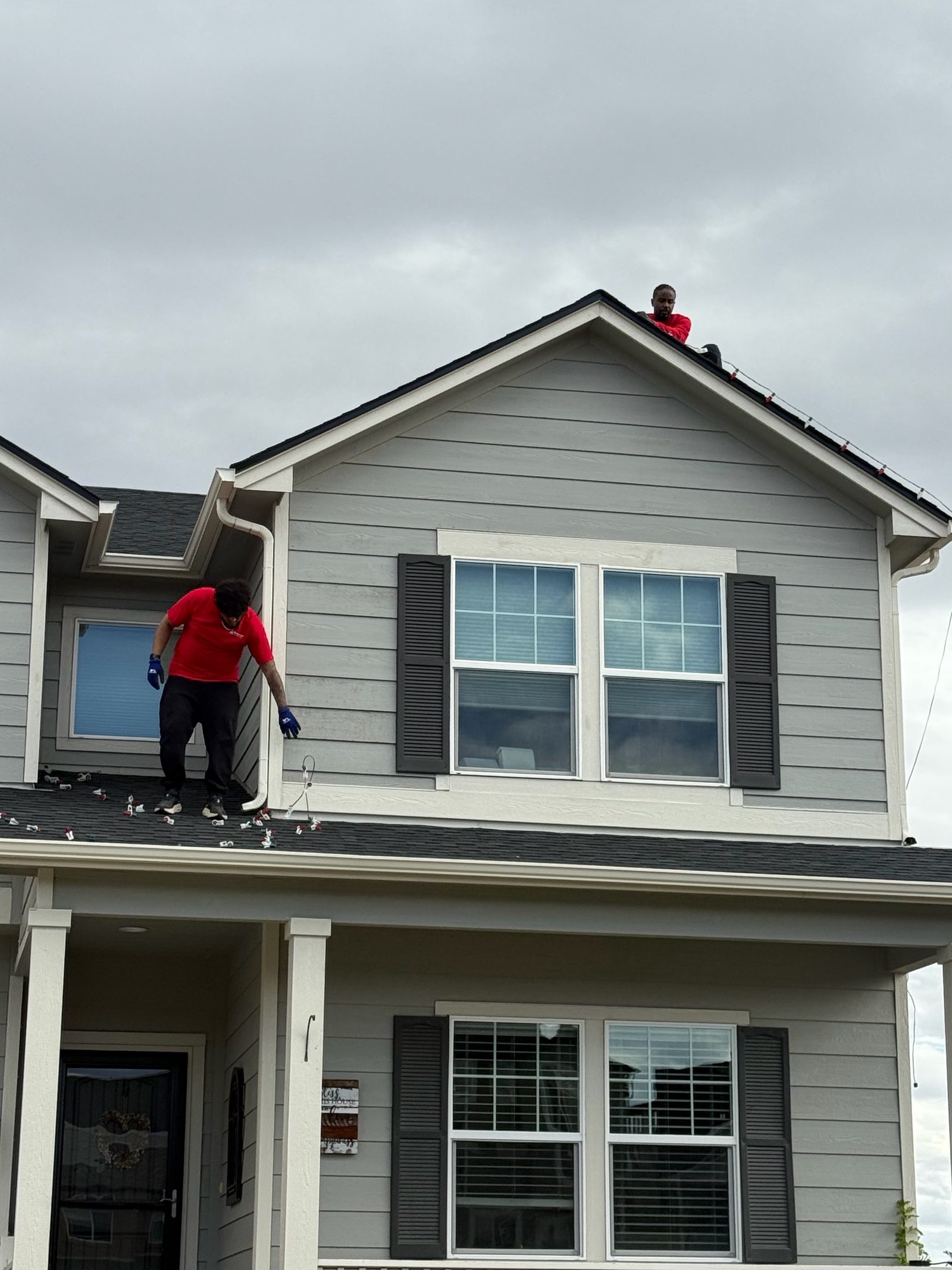 Professional Christmas light installation crew on roof installing LED lights on the Colorado Front Range