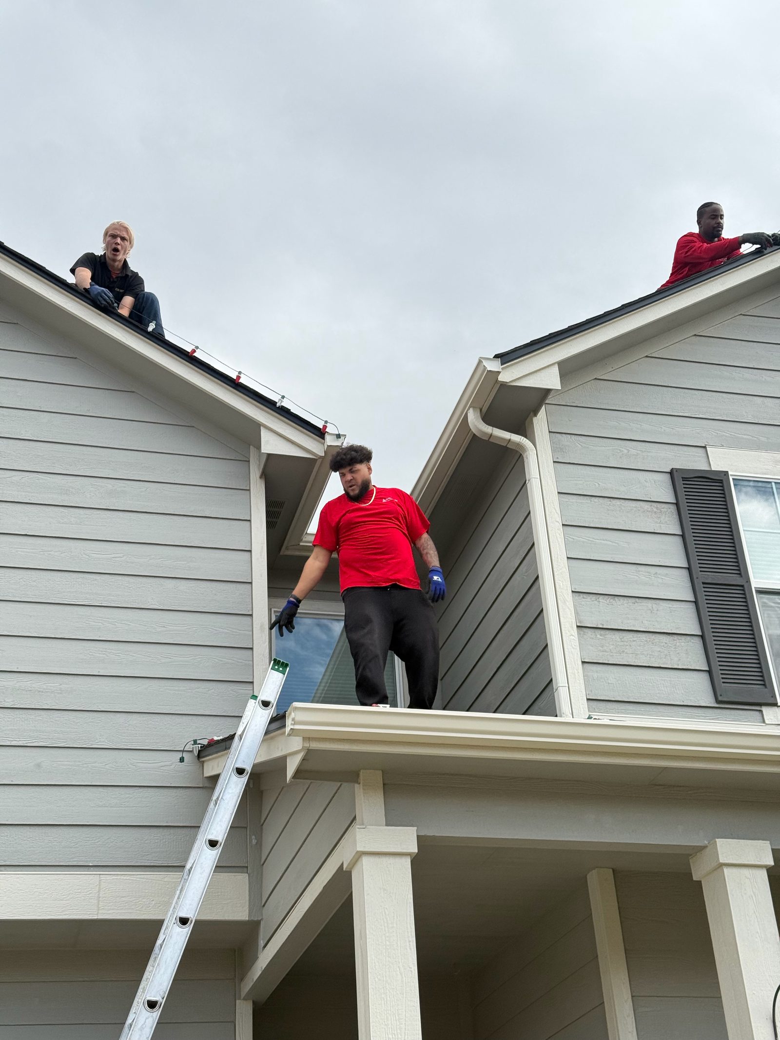 Christmas Lights Colorado Springs team installing multicolor Christmas lights along roof peaks